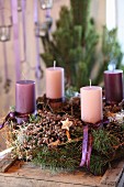 Rustikaler Adventskranz mit Kerzen in Lila und Violett