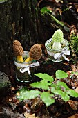 Crocheted toadstools in jars on mossy tree stump