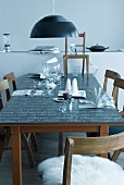 Blackboard table set with punchbowl and cups under black pendant lamp