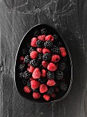 Fresh blackberries and raspberries in a dish (view from above)