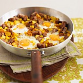 Hash browns with pieces of sausage, sweetcorn and fried eggs