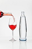 Rosewein einschenken neben einer Wasserflasche