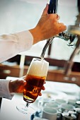 A waitress pouring draught beer