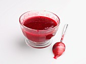 Fruit sauce in a glass bowl and on a spoon