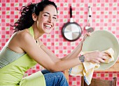 Young woman drying a plate