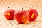 Drei rote Äpfel mit Weihnachtsmotiven