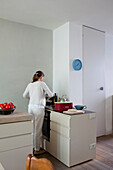 Frau beim Kochen in einer minimalistischen Küche