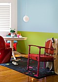 Wohnraum mit farbigen Wänden, rundem Holztisch, Schwingstühlen & Armlehnstuhl