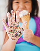 Asiatisches Mädchen mit Zuckerstreuseln an der Hand