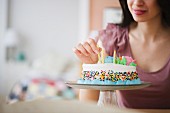 Mixed race woman preparing birthday cake