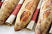 Three baguettes in a row on a linen cloth