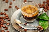 Espresso in a glass with coffee leaves and coffee beans