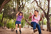 Two sisters on swings in park