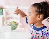 Kleines Mädchen mit voller Salatschüssel