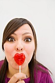 Hispanic woman with heart-shaped lollipop