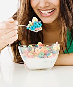 Frau isst Cerealien mit Milch