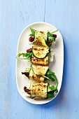 Grilled, rolled strips of courgette stuffed with sundried tomatoes, feta and rocket