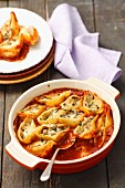 Pasta shells with mushroom and cheese filling in tomato sauce, baked in the oven