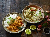 Red and green chicken curry with rice and noodles (India)