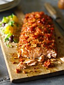 Baked salmon with crisp topping on a chopping board