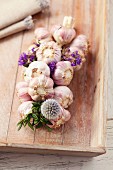 Plaited garlic with flowers on a chopping board