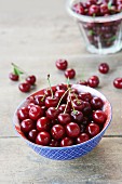 Fresh cherries in a blue and white bowl on a wooden surface