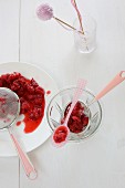 Defrosted raspberries with a sieve and a plastic spoon