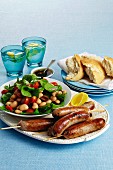 Skewered sausages with a bean and olive salad