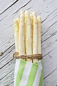 White asparagus, tied in a bundle, in a striped cloth