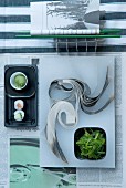 Modern, Oriental place setting with sushi and seaweed on newspaper