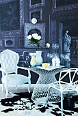 Modern, metal lattice chair and white, postmodern armchair at table with wedding symbols on top