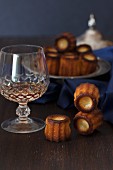 Canelés de Bordeaux (sweet French cakes) and liqueur in a crystal glass