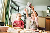 Two children baking biscuits in a kitchen