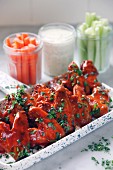 A tray of buffalo chicken wings accompanied by carrots, celery and ranch dressing