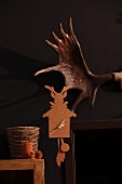 Cork wall clock next to partially visible antler on black wall