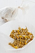Client camomile flowers in teabags, one open and one tied
