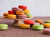 Various coloured macaroons on a cake stand and next to it