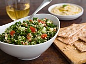 Tabbouleh with parsley, cucumber and tomato and crackers and hummus