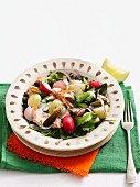 A potato salad with salmon, radishes and gherkins