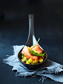 A spoonful of raw salmon with mango salsa