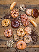 Various glazed pastries and coffee beans on a rustic wooden table