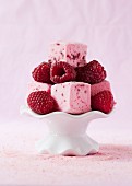 Raspberry marshmallow cubes with fresh raspberries on a mini cake stand