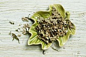 Dried mugwort with flowers in a leaf-shaped bowl