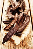 Carob bean pods in a wooden dish