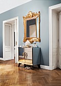 Opulent, Baroque mirror combined with mirrored, Art Deco cabinet in hallway of stylish, Viennese period apartment