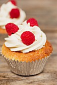 Cupcakes mit Buttercreme und Himbeeren