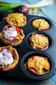 Various party snacks in a muffin tin