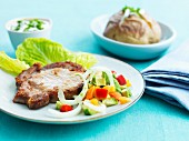 Schweinekotelett mit Salat und Ofenkartoffel