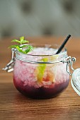 A blackberry cocktail with rum and ice cubes