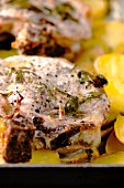 Grilled pork steaks with lemon and sage served on roast potatoes